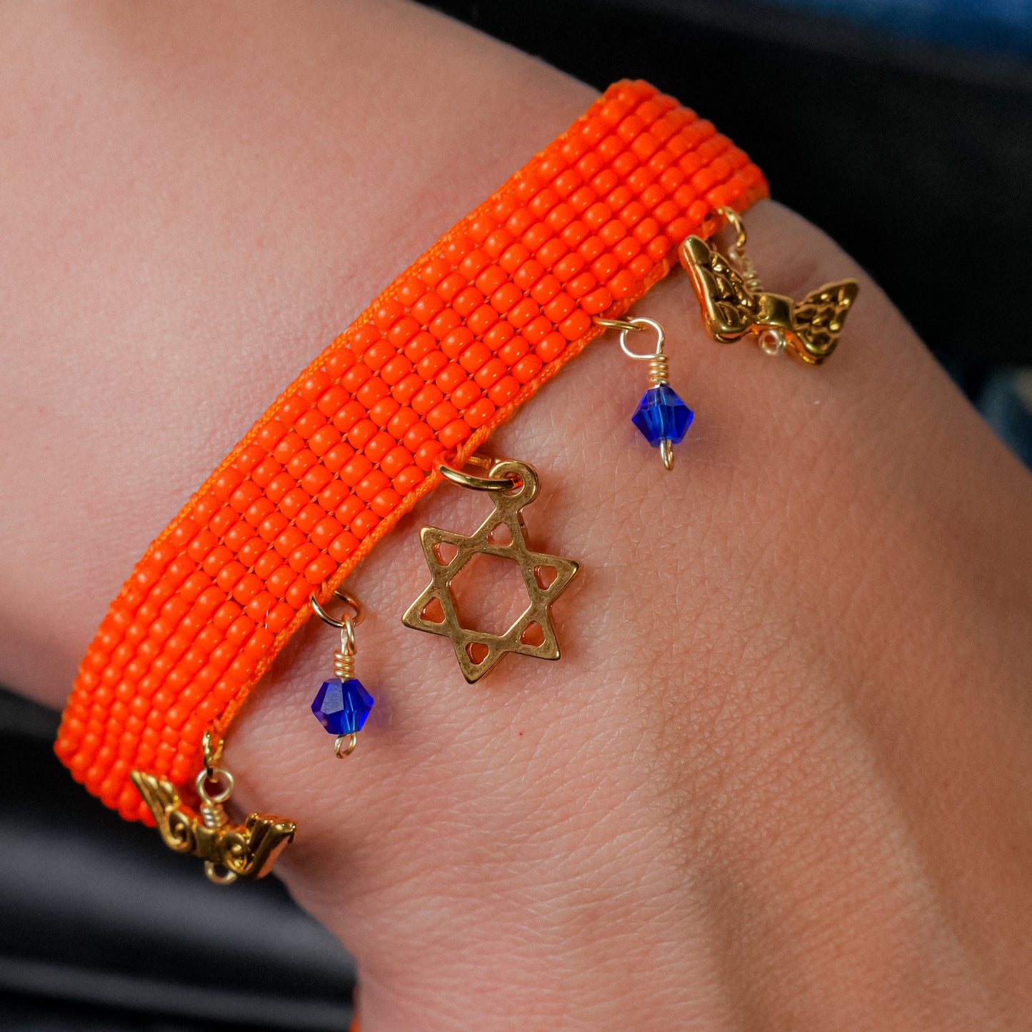 Pulsera tejida naranja con dijes colgantes con dije de estrella