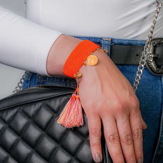 Pulsera tejida naranja con dije de FE