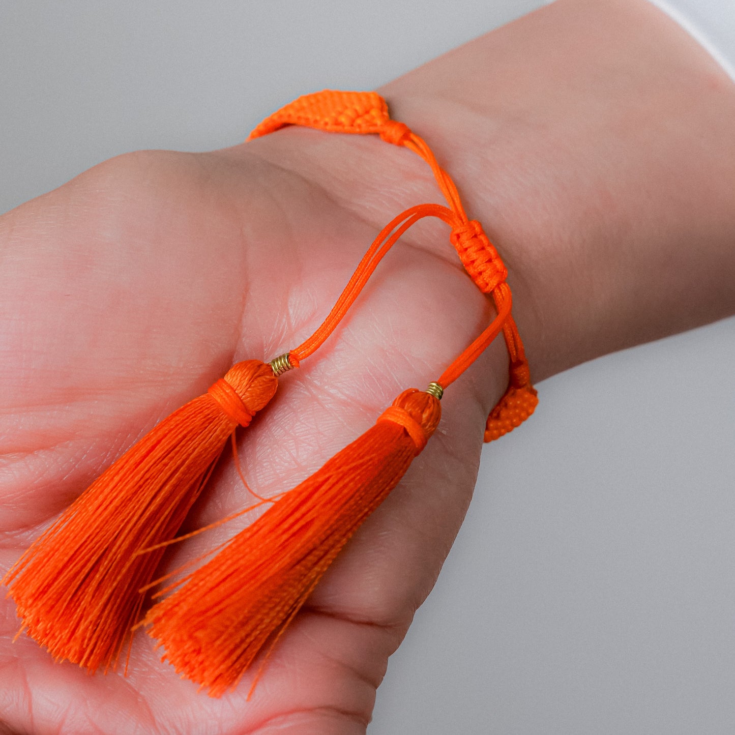 Pulsera tejida naranja con dijes colgantes con dije de estrella