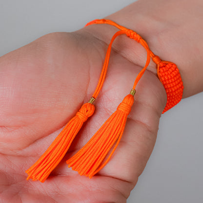 Pulsera tejida naranja con dijes de osos